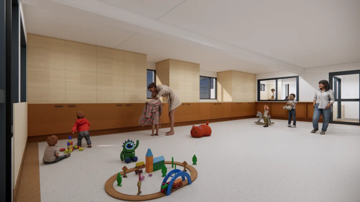 A large, multipurpose room. Cupboards line one wall, and a large window looks into the kitchen.