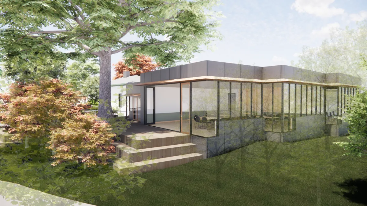 Looking in to a large multipurpose room from outside. The 2 exterior side are large windows and doors that open right up to create an inside/outside space.