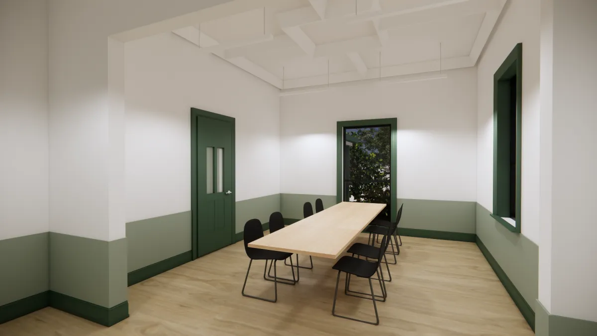 A small open space with a long table and 4 chairs either side. There is a tall window at the end of the table.