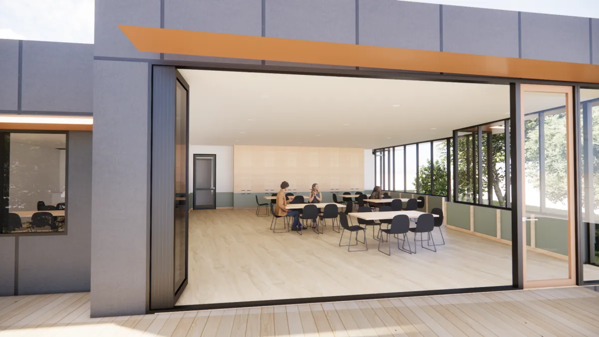 Large multipurpose room set up with 5 tables and 32 chairs, with room to spare around them. The door to out side is open wide, letting the outside in.
