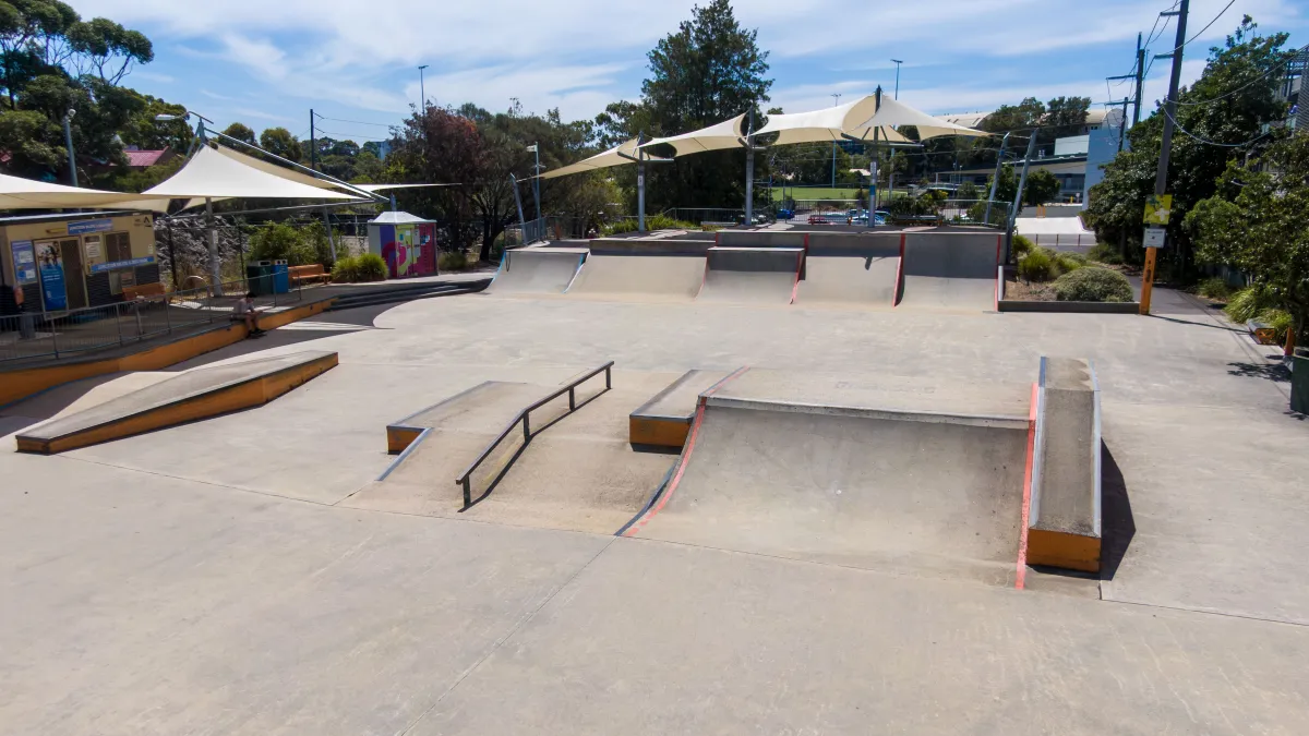 A skate park with ramps, rails and ledges.