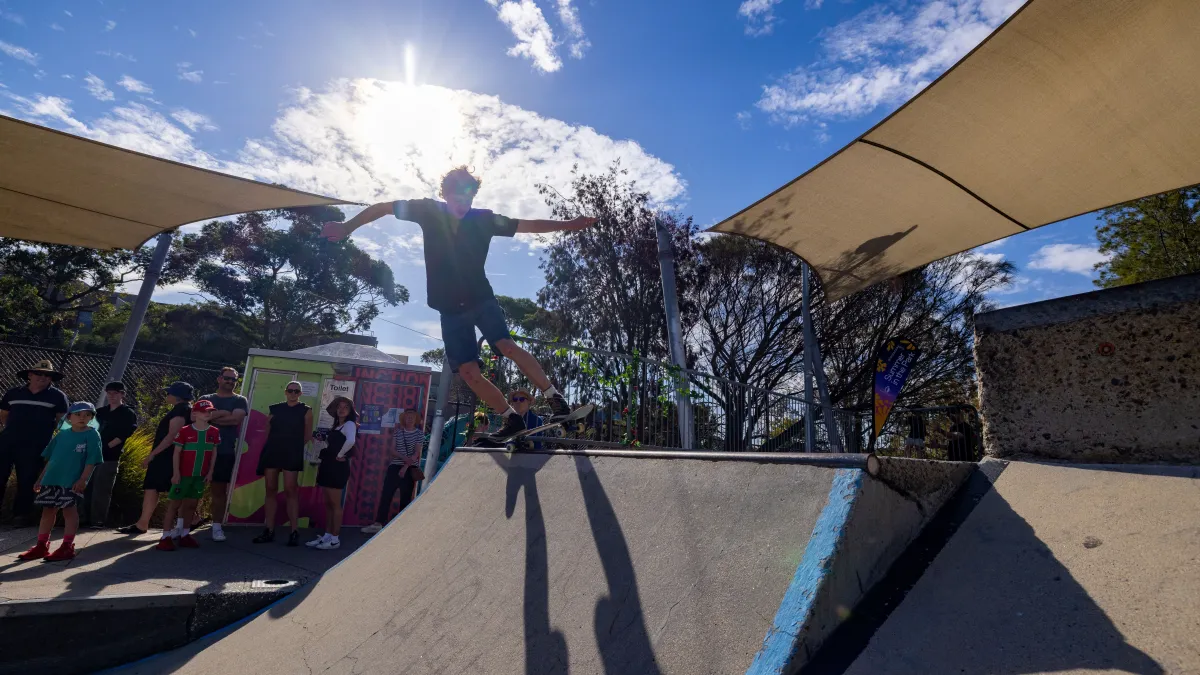 Kids skateboarding in an outdoor skatebowl with sun shades