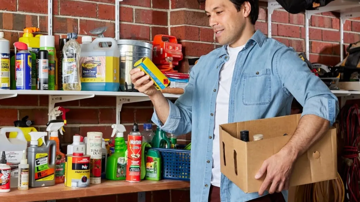 A man inspects a shelf full of household chemical products