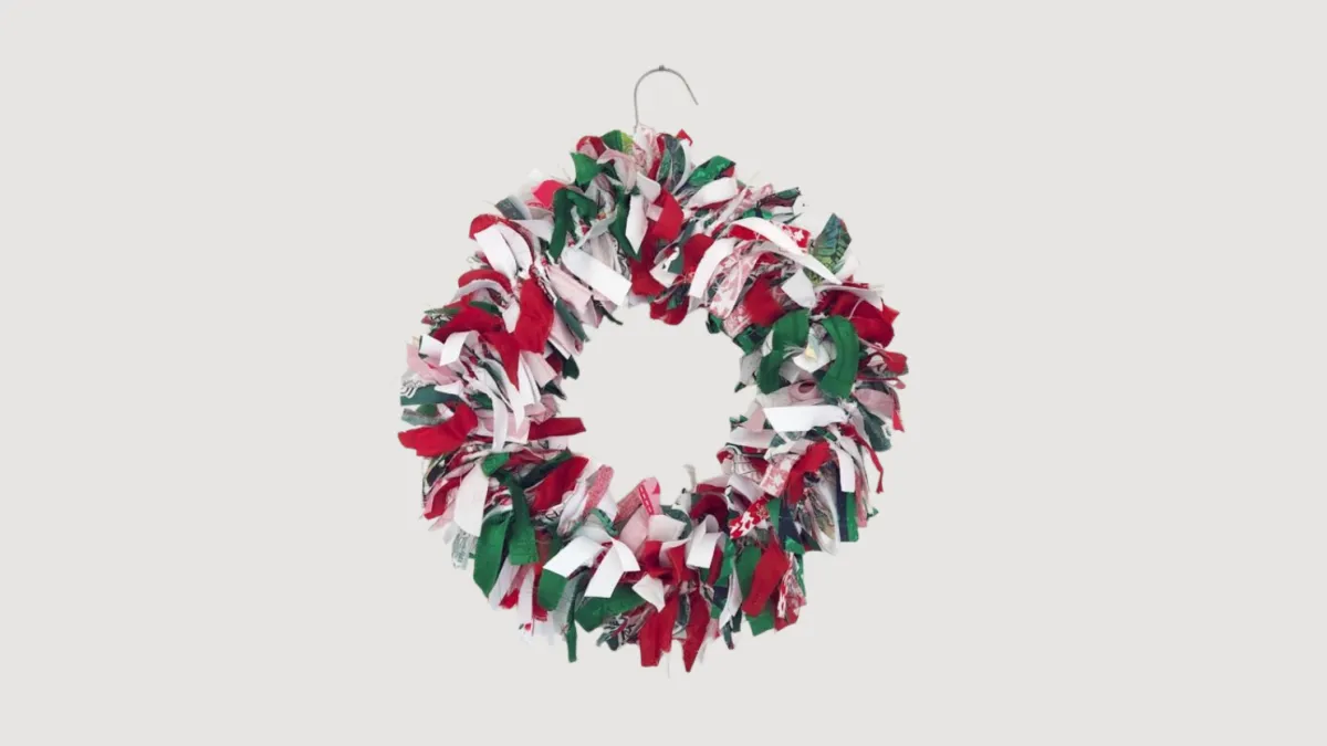A Christmas wreath made from strips of green, red and white fabric.