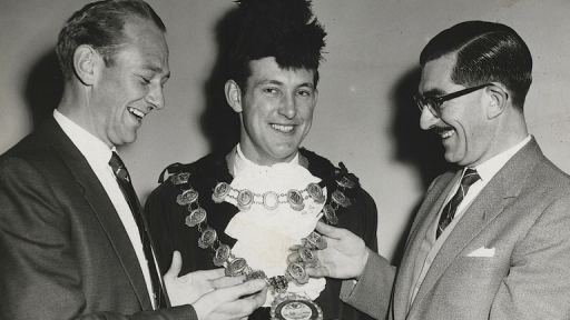 John Peck smiling widely while wearing the mayoral chains