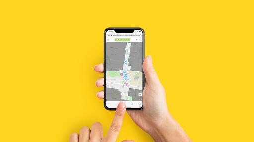 A pair of hands holds a mobile phone with a map on the screen