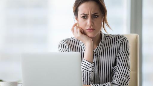 Woman frowning at laptop
