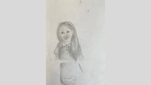 Graphite drawing of a girl sitting at a desk. She has a pencil and paper in front of her. She has long loose hair, is wearing a headband and is smiling.