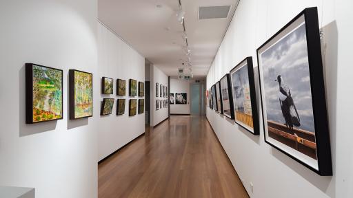 Installation view of 'Natural Constructs' at Town Hall Gallery. Paintings of water and trees by Justine Siedle on on side and urban photographs by Jackie Winkelman on the other.