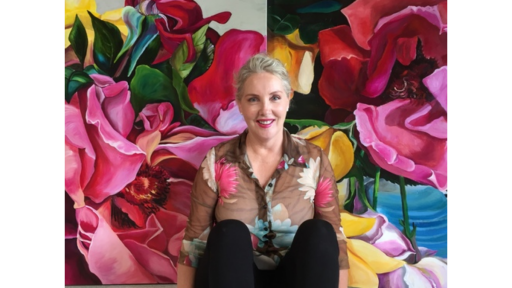 Artist Shani Alexander sitting in front of her large scale flower paintings.