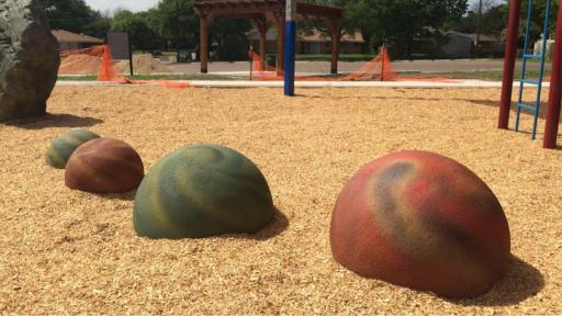 Planet spheres nestled in mulch at the Central Gardens playground renewal