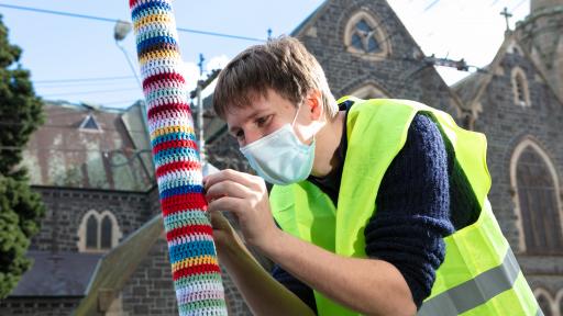 A man yarn bombing on Glenferrie Road