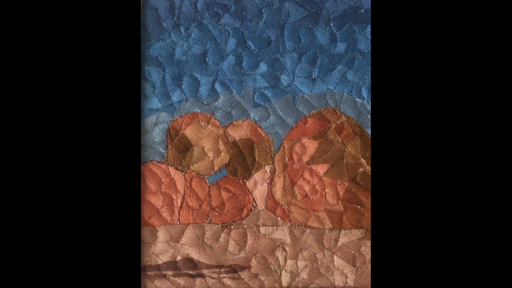 A quilted artwork depicting boulders piled up, against a blue sky.