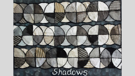 Collaged fabric, arranged into circles divided into quarters. They are all in dark and neutral tones. Under the circles is the word, "shadows".