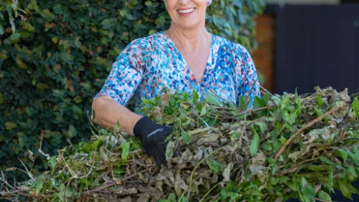 A woman holding an armful of of cut branches
