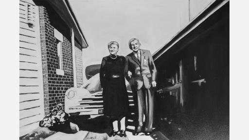 A middle aged man and woman standing in from of a car in a suburban driveway