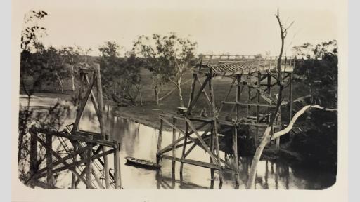Photo of a broken wooden bridge high over a river