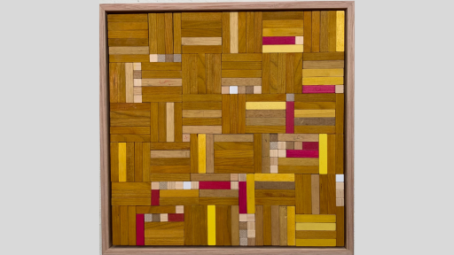 A framed piece of art that shows tesselating cubes made out of wooden rectangles that are mostly brown with some pink and some lighter yellow and light wood mixed in