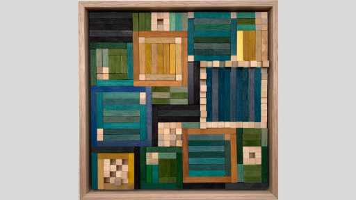 A framed piece of art made of wooden rectanges arranged in square patterns of varying sizes, and coloured a range of blues and greens, as well as light to dark browns