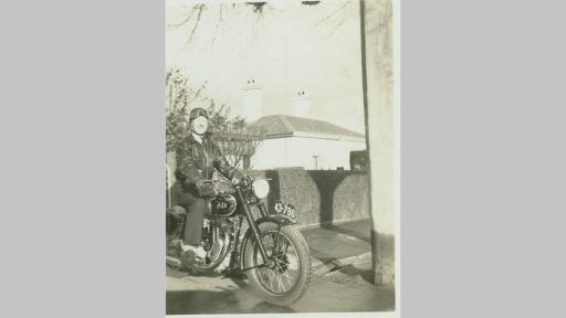 Vintage photo by Stuart Riley of a man in leather sitiing on a motorcycle on a surburban street
