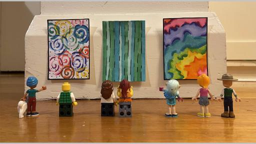 Photo by James Ding of  lego people looking at 3 proportinately sized artworks on a wall at ground level
