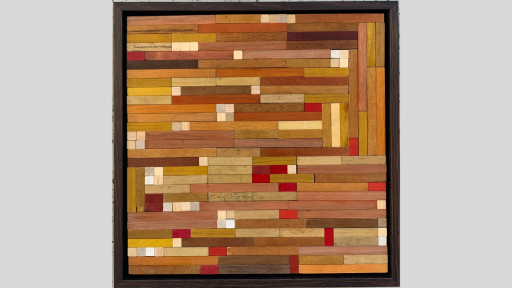 A framed piece of art made up of wooden rectangles mostly arranged to be horizonal linea but some vertical pieces mixed in, and colours ranging from light browns to whites and reds