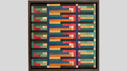 A framed piece of art made up of tesselating wooden rectangles and squares that make a rectangular repeating pattern with blues, greens, reds and pinks and light browns throughout