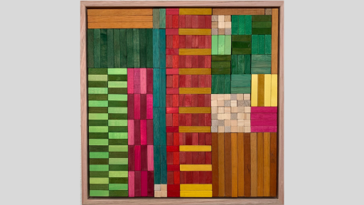 A framed piece of art made of wooden rectanges arranged in columns and squares that alternate between bright colours as well as light browns