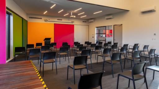 A meeting room with chairs facing a colourful stage