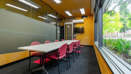 A small meeting room with a narrow desk and large picture window