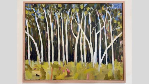 A framed piece of art showing a forest of trees with white trunks and green foliage