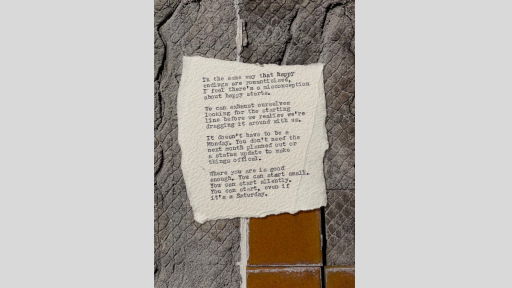 A piece of torn paper with a poem printed from a typewriter, sitting on a textured surface