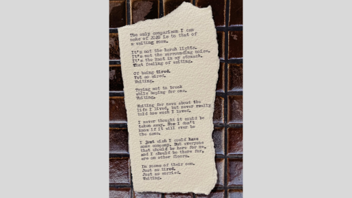 A piece of torn paper with a short piece of text printed from a typewriter, sitting on a brown tiled surface