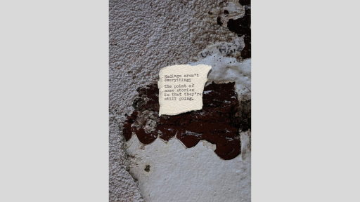 A piece of torn paper with a short piece of text printed from a typewriter, sitting on a textured surface