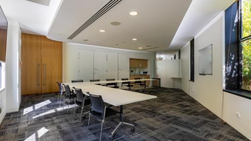 A carpeted meeting room with an L-shaped table