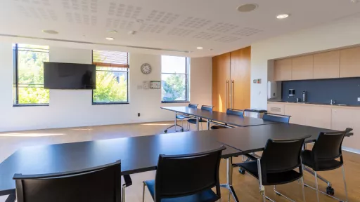 View from a meeting room table towards a wall-mounted TV