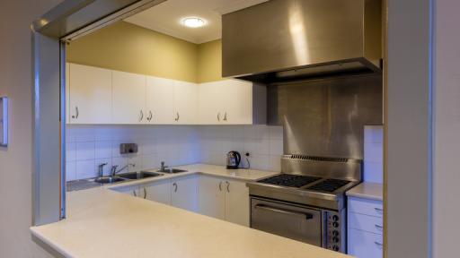 A small kitchen with stainless steel rangehood