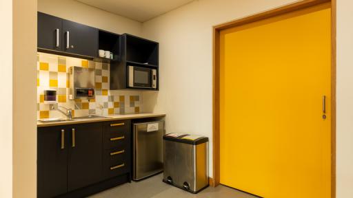 A small kitchen with a bright yellow door