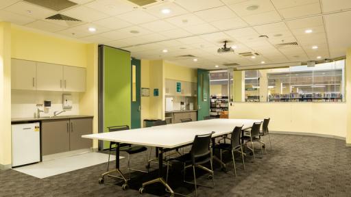 A meeting room with a boardroom table and bright green door