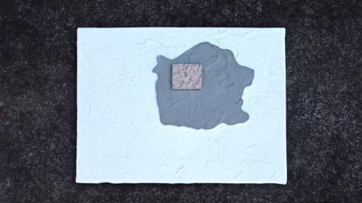 A ceramic artwork of a square on a textured, painted backdrop