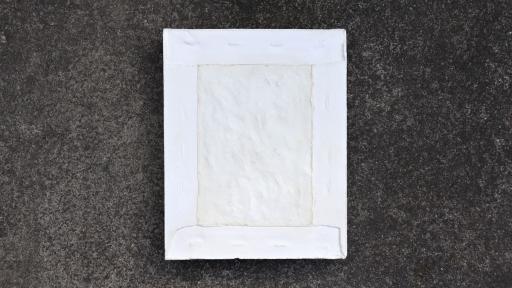A ceramic artwork of a white rectangle with textured surface