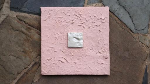 A pink painted square with a small inlaid white square artwork