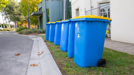 6 recycling bins on a streetside kerb