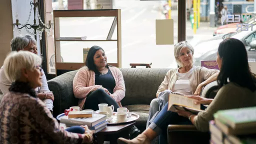 5 people sitting on couches holding books