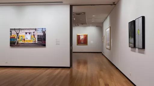 paintings on the wall of an art exhibition