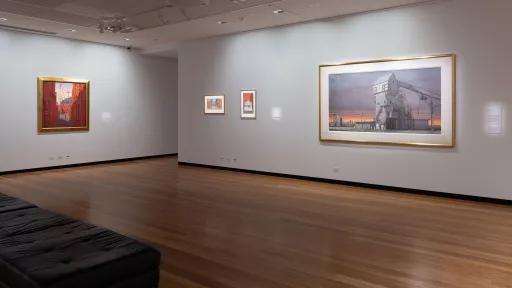 Painting of an industrial building on the wall of an art gallery