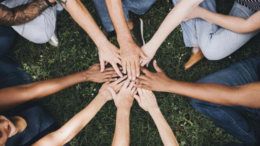 A group of people with their hands together in a circle