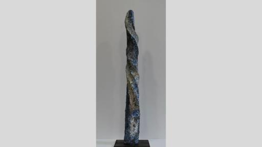 Elongated sculpture with pocked and twisted surface