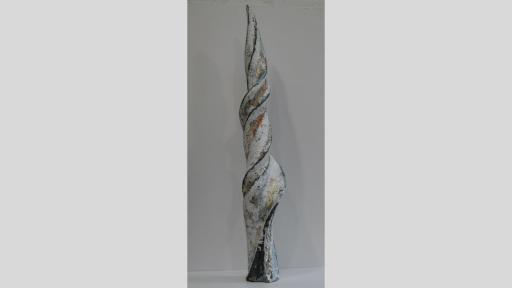 Vertical sculpture of a thick, twisted shape like a unicorn horn in white, gold and blue