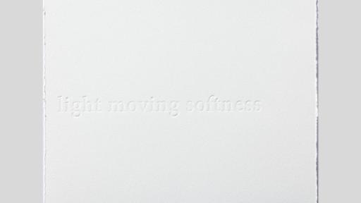 A white canvas with frayed edges and embossed the words 'light moving softness'